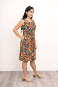 Side view of woman in sleeveless floral dress with hands in pockets