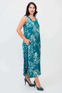 Side view of model in teal floral print tank dress with midi hem and pockets