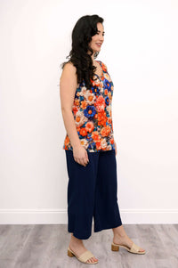 Side profile of a woman in a vibrant floral bamboo tank top and navy pants