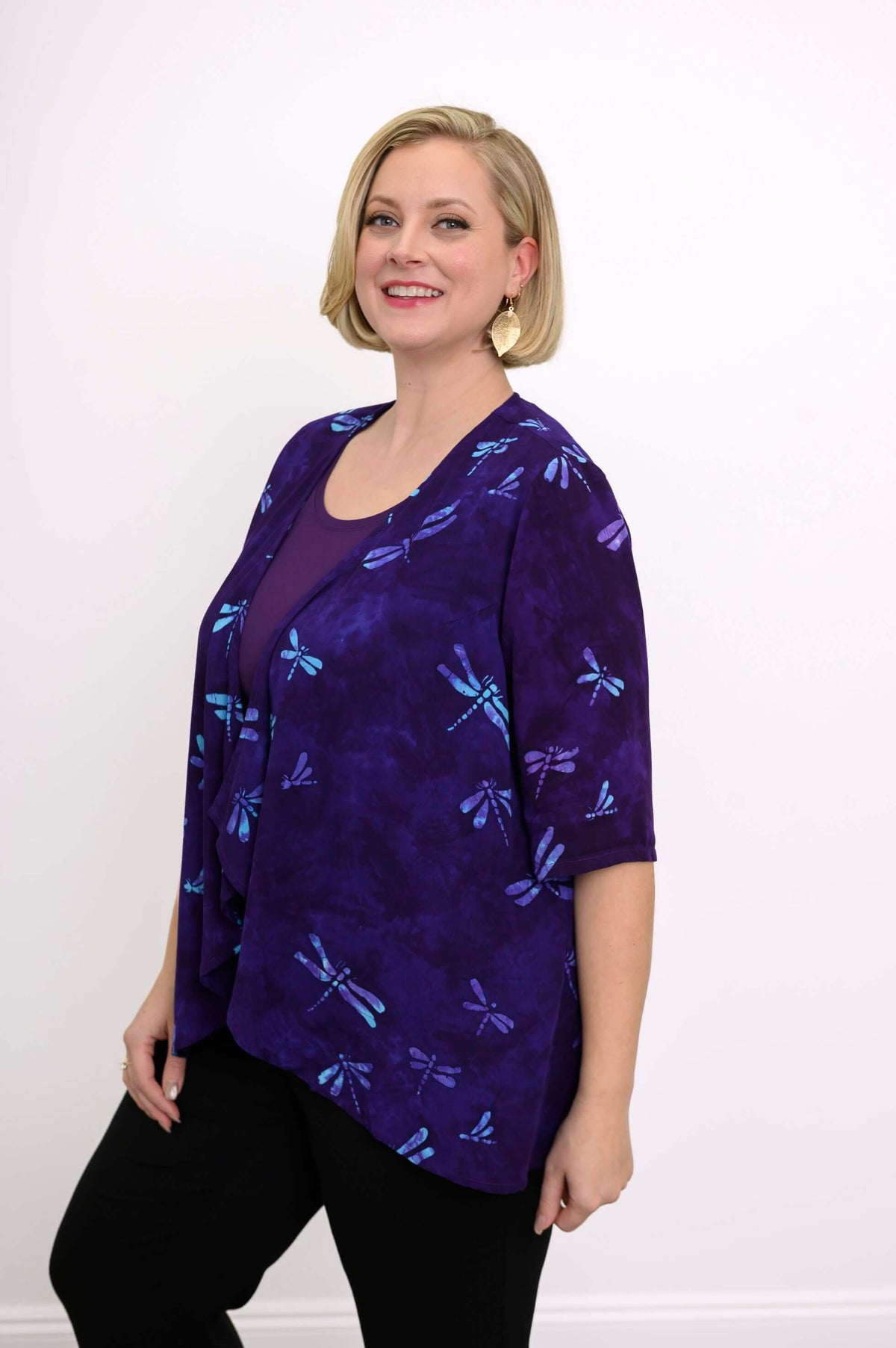 Side angled view of woman in Toucan Jacket with purple and blue dragonfly pattern