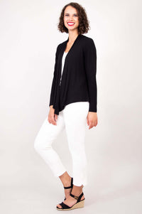 Side view of woman in black bamboo cardigan paired with white pants and sandals
