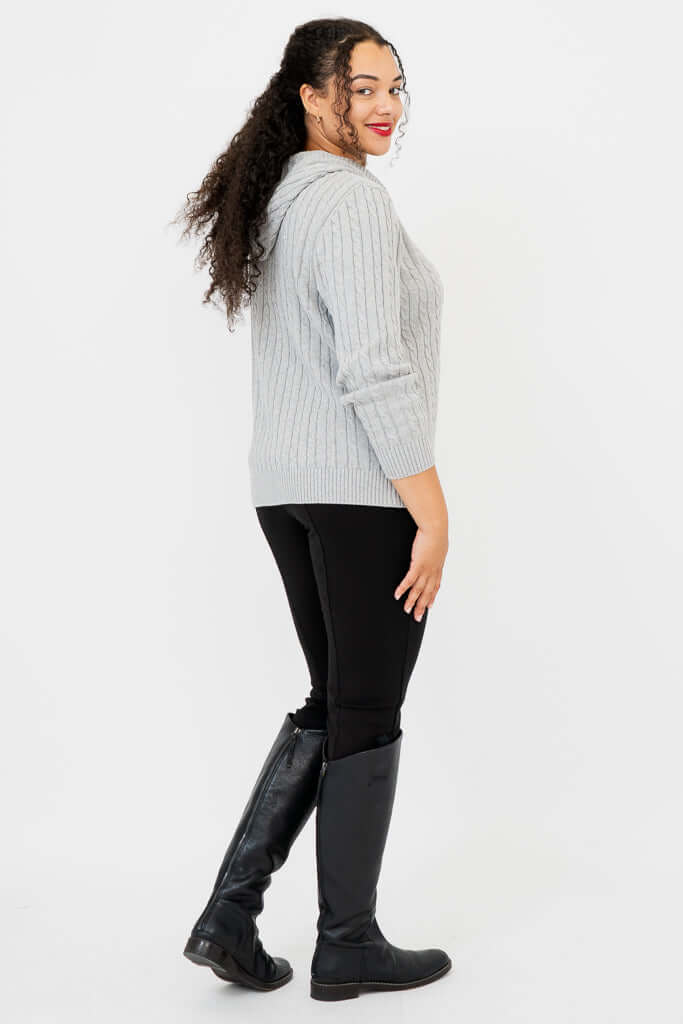 Side view of woman wearing light grey cable knit sweater hoodie
