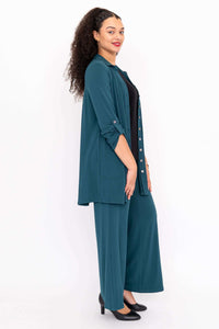 Side view of woman in teal wide leg pants, matching shirt, and black heels