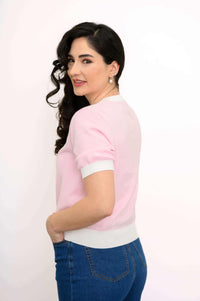 Side view of woman in retro pink sweater with short sleeves and ribbed trim