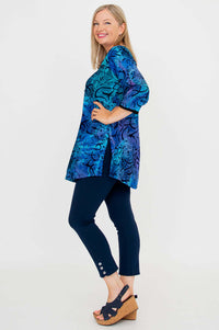 Side view of woman modeling blue and purple batik blouse with side slits and ¾ sleeves