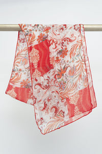 A red and white floral patterned silk scarf draped over a rod against a white background, front view