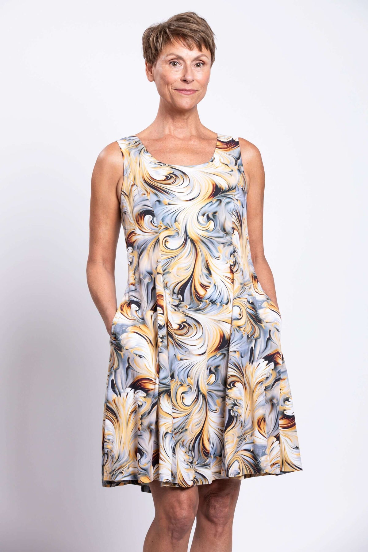 Close up of sleeveless swirl print dress with pockets, modeled by a woman