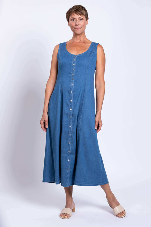 Woman wearing a sleeveless blue Tencel denim maxi dress with front buttons