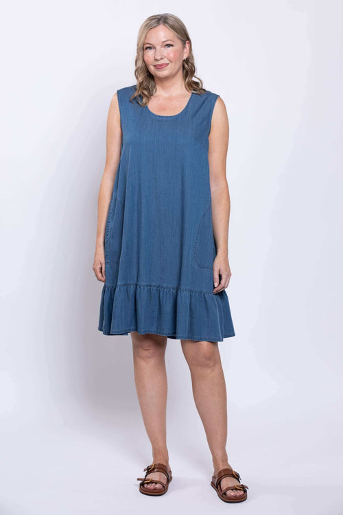 Woman modeling sleeveless blue dress with round neck and ruffle hem, front view