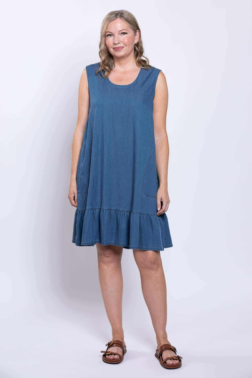 Model showing sleeveless blue dress with ruffle hem, facing forward