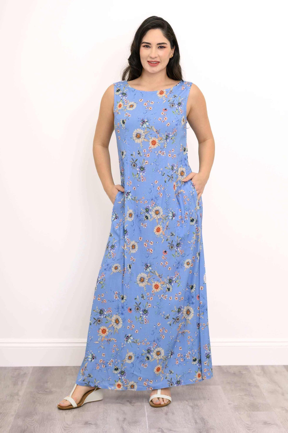 Model wearing a sleeveless blue floral maxi shift dress facing forward