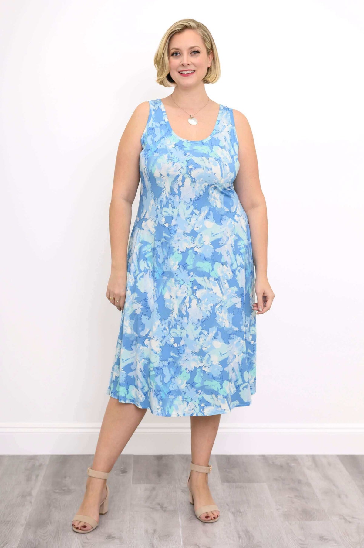 Woman wearing a sleeveless blue watercolor print tank dress, front view