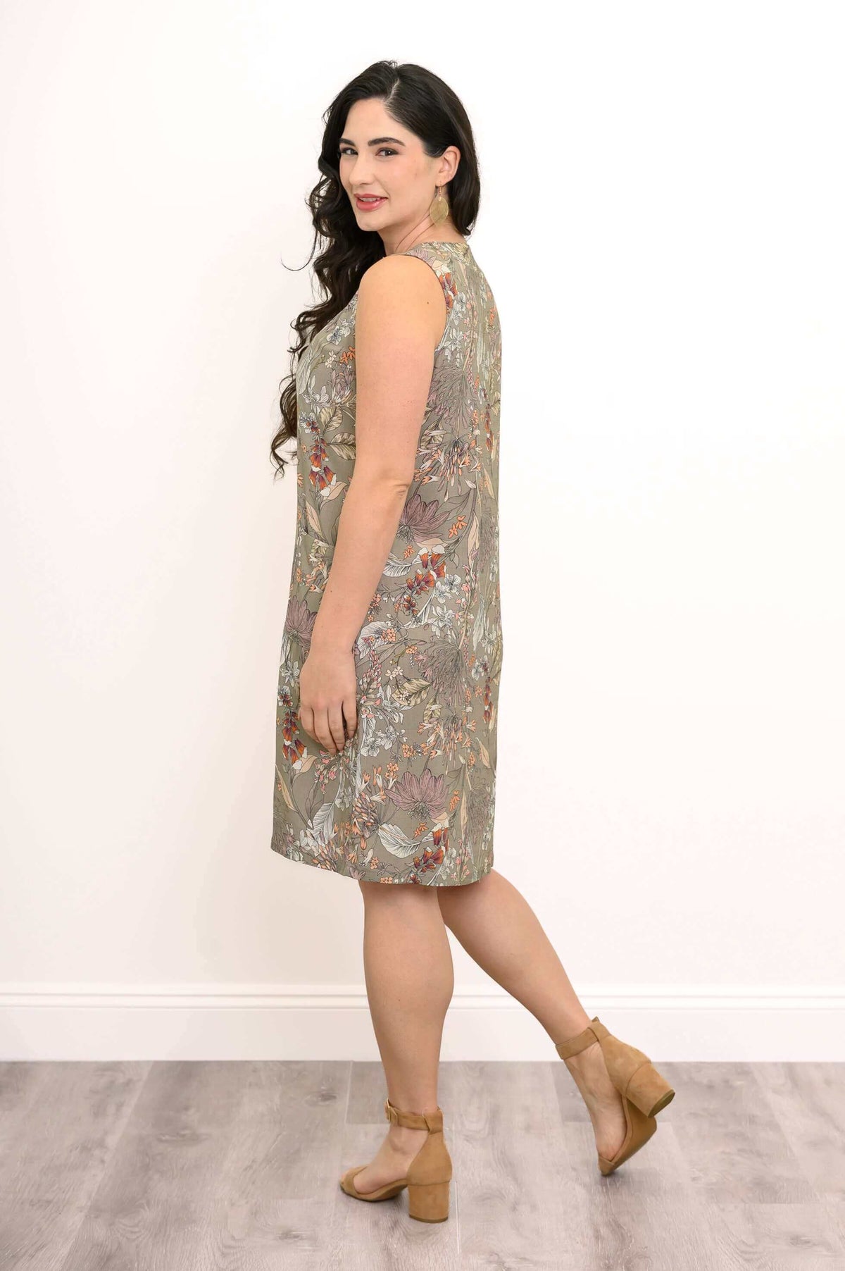 Side view of a woman in a sleeveless floral shift dress with a floral pattern
