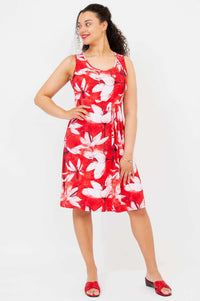 Woman wearing a sleeveless red floral dress with pleated empire waist facing forward