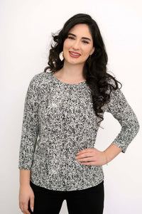 Smiling woman posing in a black-and-white rose print fitted basic tee