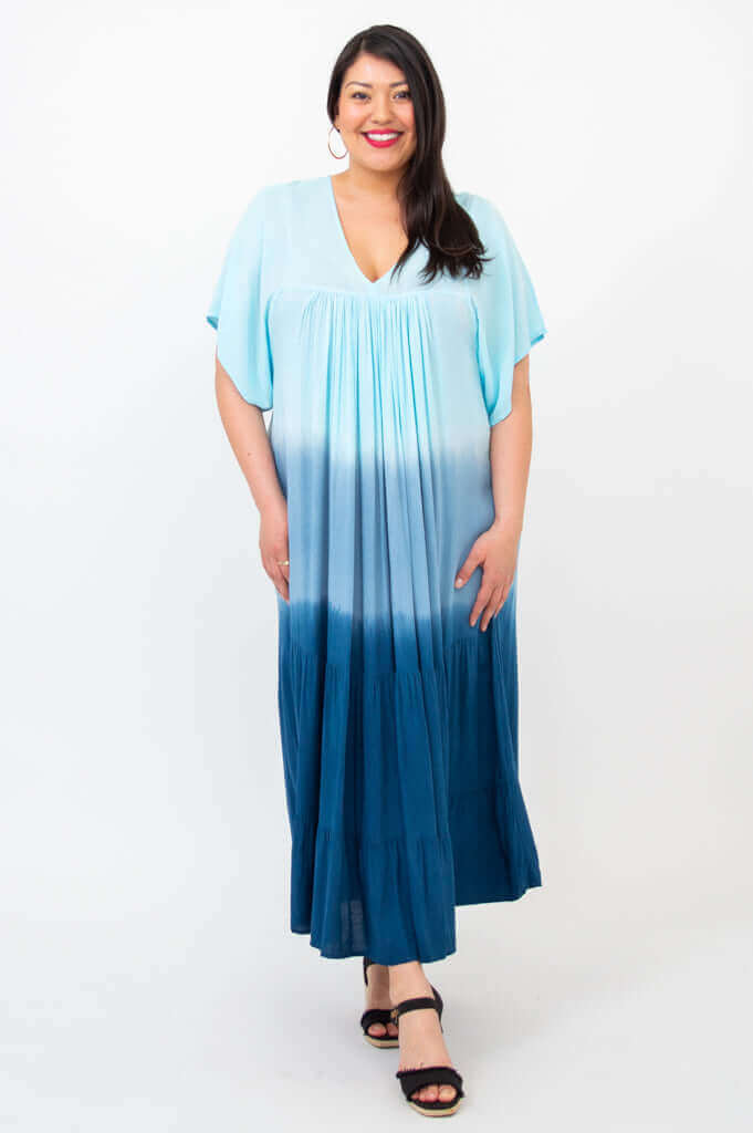 Woman smiling in blue ombre tiered maxi dress, facing forward