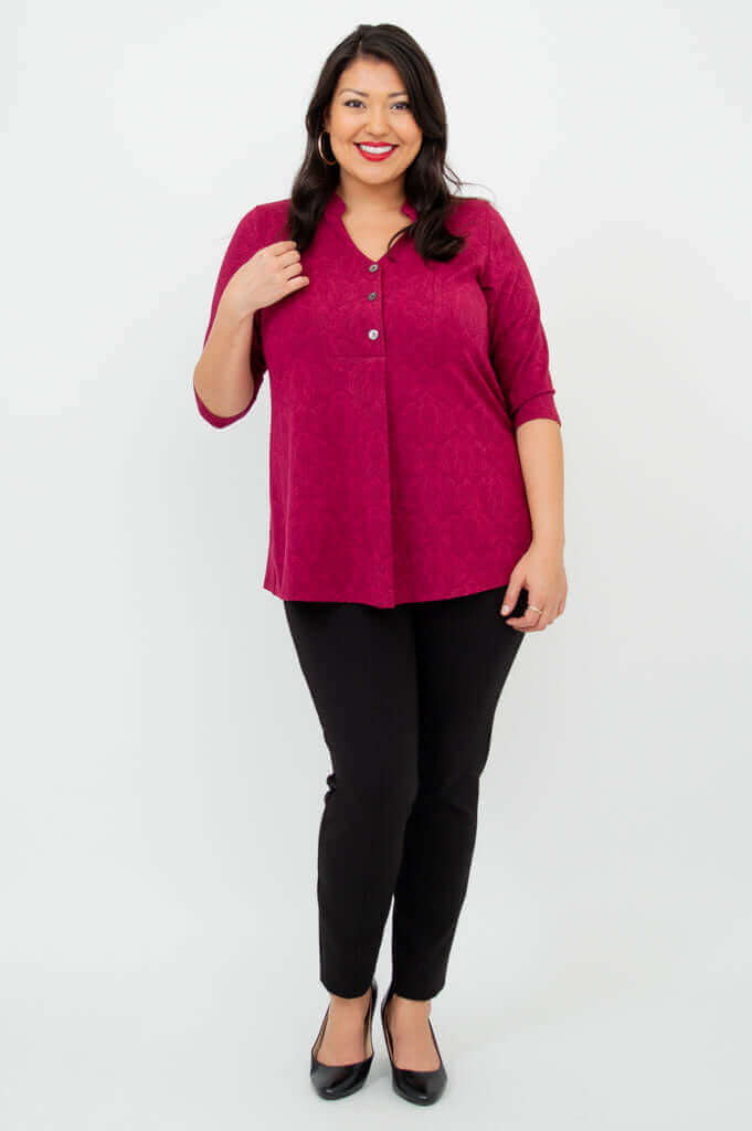 Smiling woman wearing raspberry bamboo top with mandarin collar and three-quarter sleeves