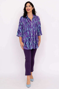 Woman smiling in Cindy dragonfly violet tunic and violet pants, standing straight