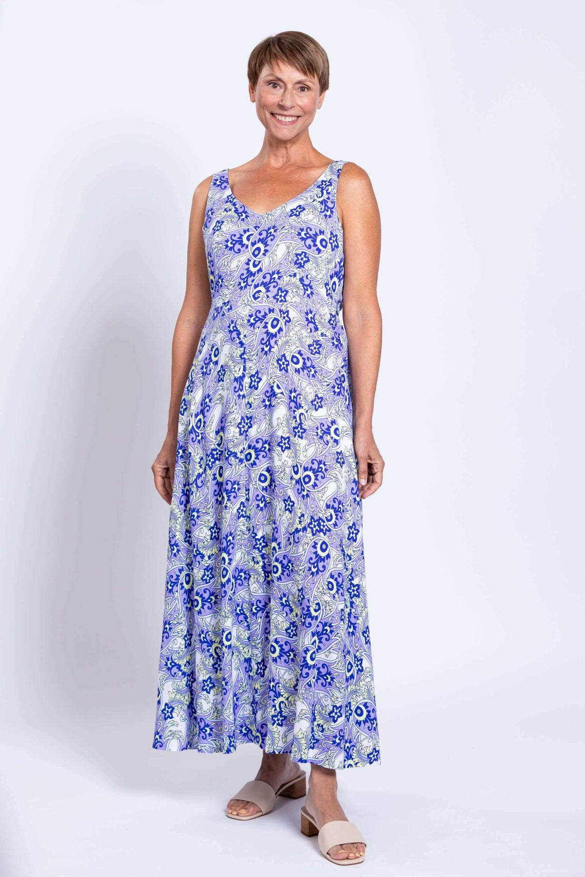 Woman smiling in a blue and white maxi dress with empire bust and subtle v-neck
