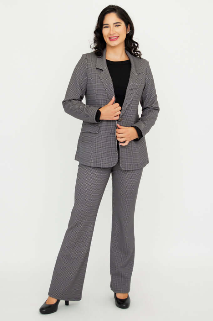 Woman smiling and posing in a fitted checkered blazer and matching pants
