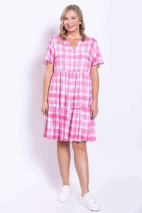 Woman smiling in pink check dress with V notch neckline and two skirt panels
