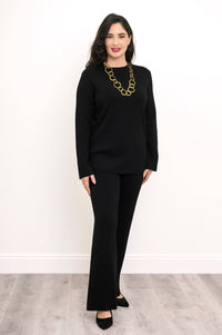 Angled view of an ebony long-sleeve knit top on a model, showcasing a comfortable, body-skimming silhouette.