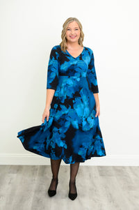 Front view of a woman modeling a blue patterned bamboo cotton midi dress styled with simple black heels.