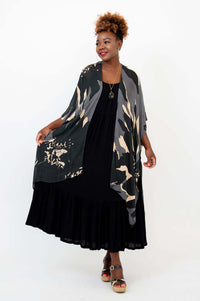 Model with arms outstretched wearing loose, printed Darcy kimono wrap