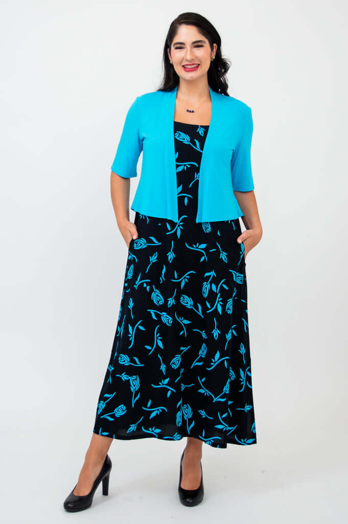 Woman in black dress with blue print and matching turquoise jacket