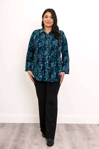 Model standing in blue floral smocked shirt and black bootcut pants