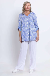 Full front standing view of blue paisley tunic and white pants outfit