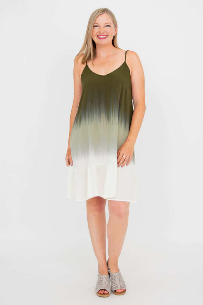 Woman standing in olive ombre dress, hands at sides