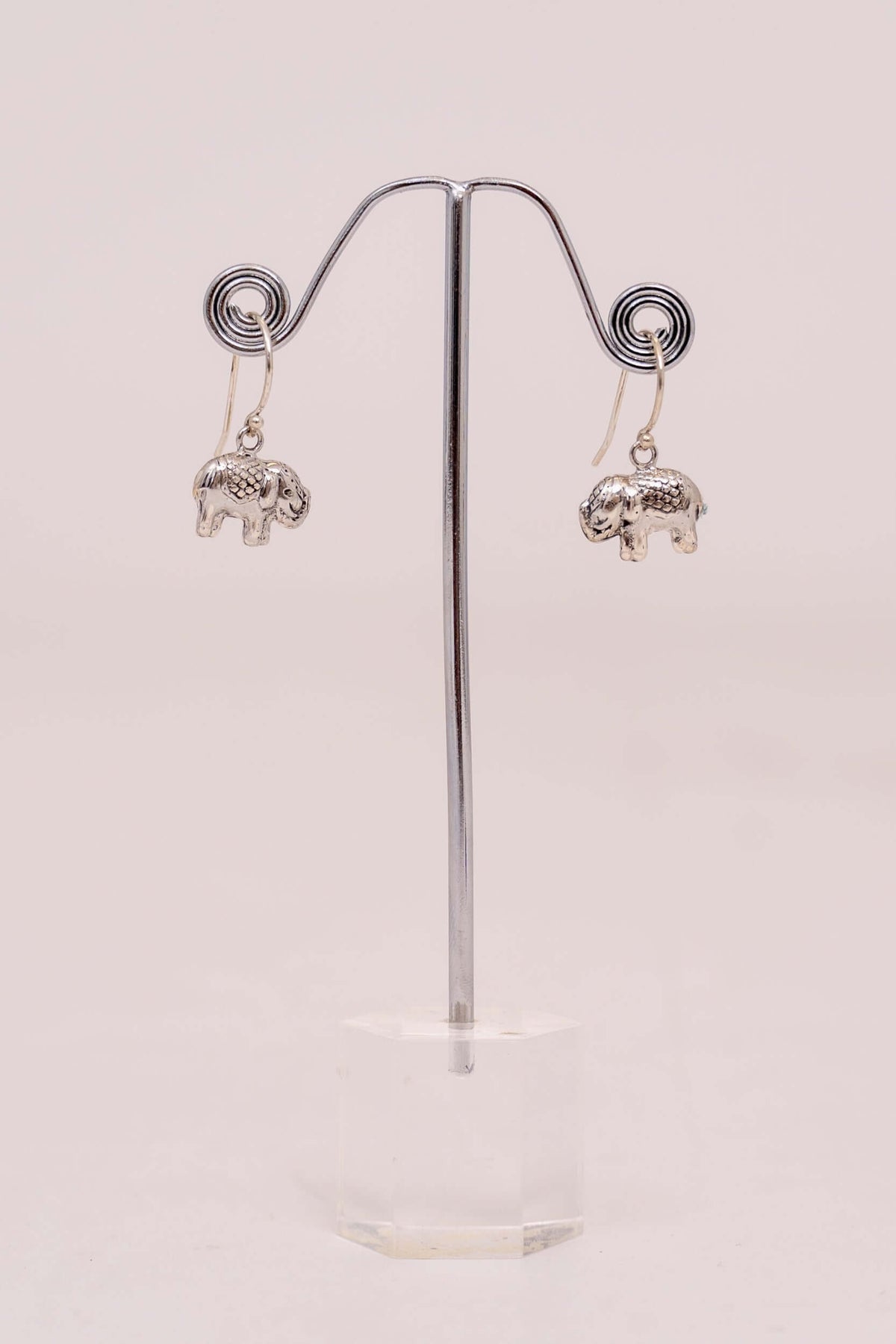 Pair of 925 sterling silver elephant drop earrings displayed on a stand