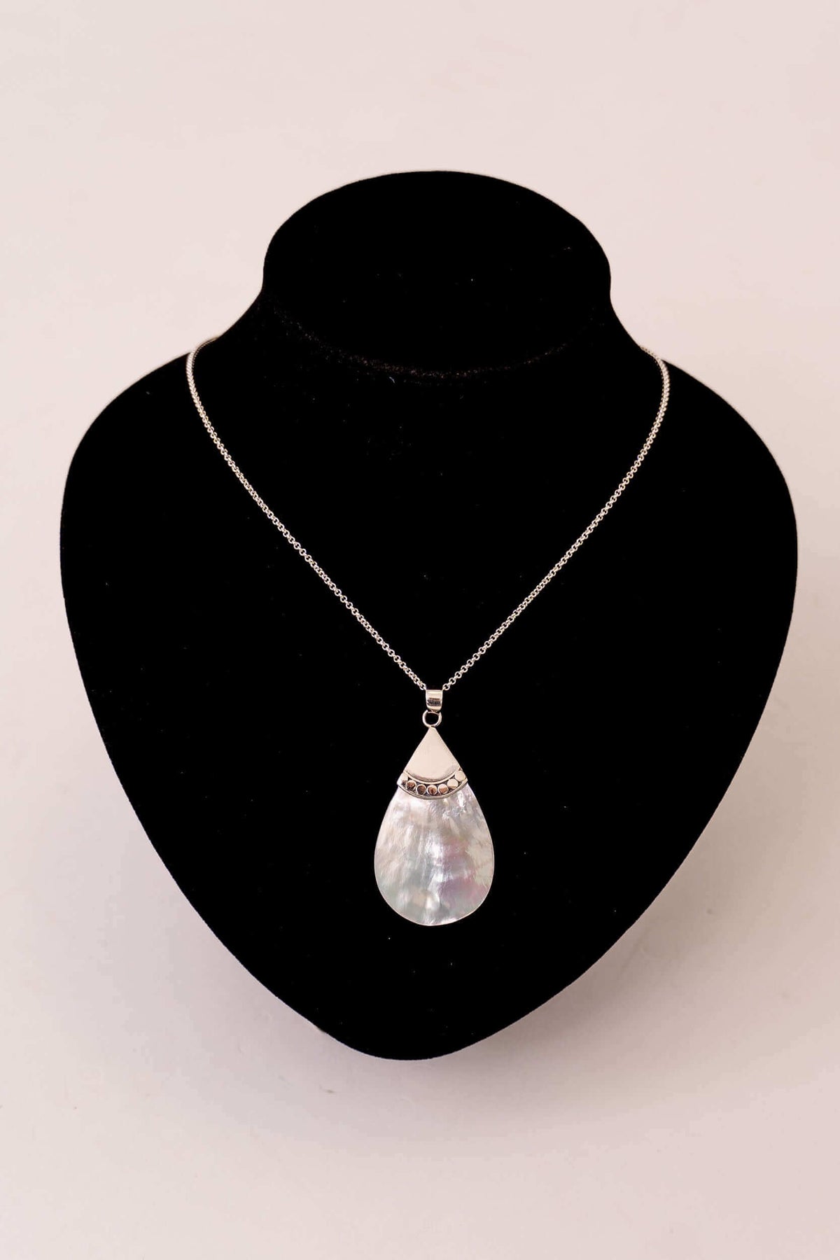 Sterling silver teardrop pendant necklace displayed on a black velvet bust