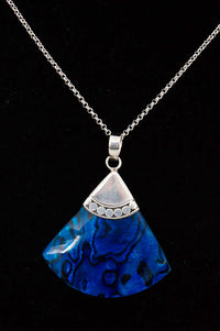 Sterling silver necklace with blue abalone fan pendant on black background