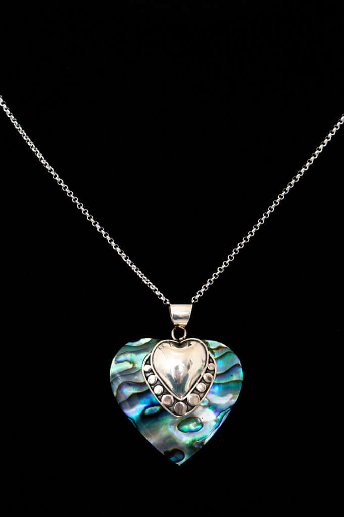 Sterling silver necklace with iridescent heart pendant on black background