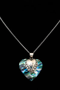 Sterling silver necklace with iridescent heart pendant on black background