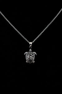 Sterling silver necklace with a finely crafted turtle pendant on a black background