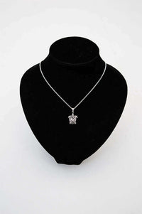 Sterling silver turtle pendant necklace displayed on a black jewelry bust