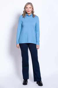 Straight-on front view of model in light blue sweater and navy trousers