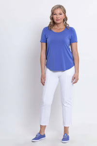 Straight-on standing view of woman in blue Tessa Tee and white pants
