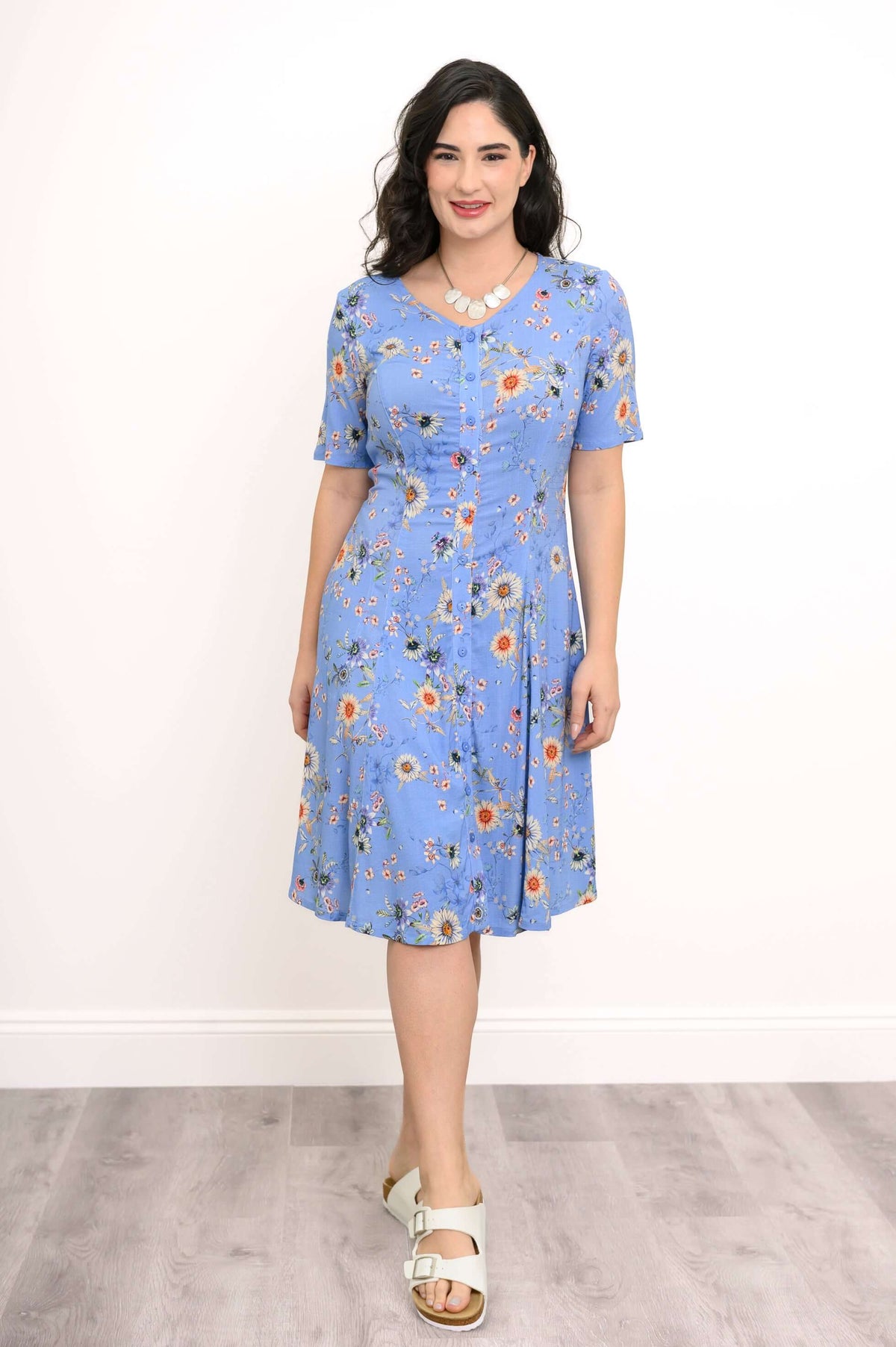 Straight-on view of a blue floral dress with princess seams and short sleeves
