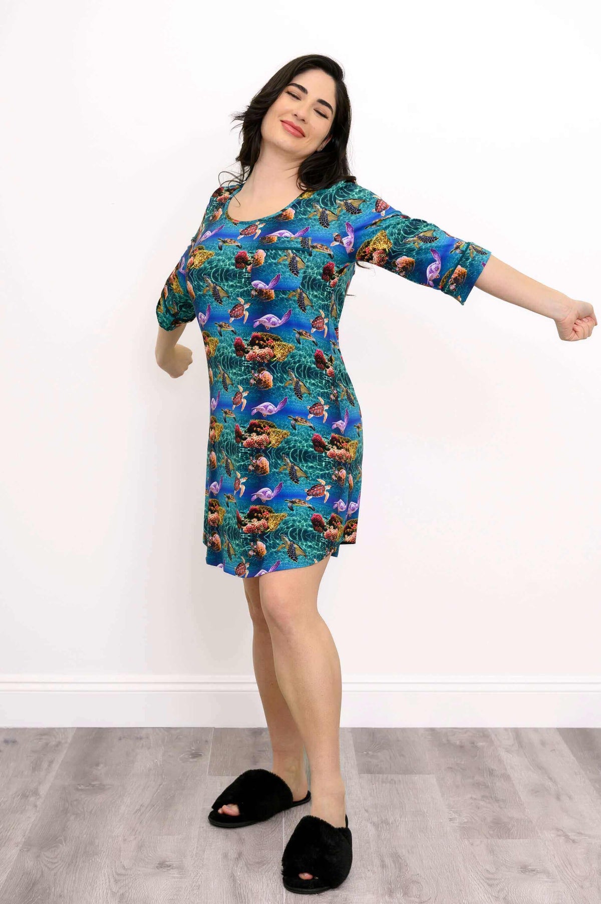Woman stretching joyfully in a vibrant ocean print bamboo sleepshirt
