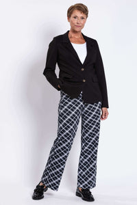 Woman wearing plaid trousers styled with a black blazer and white top