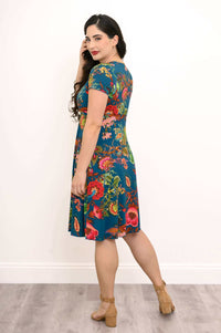 Back angled view of woman in teal floral bamboo dress, highlighting floral print