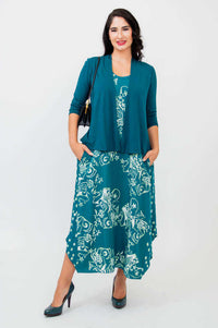 Model with teal open cardigan over matching floral tank dress, holding a purse