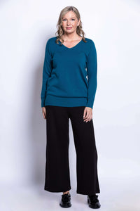 Front view of woman modeling teal v-neck sweater with long sleeves