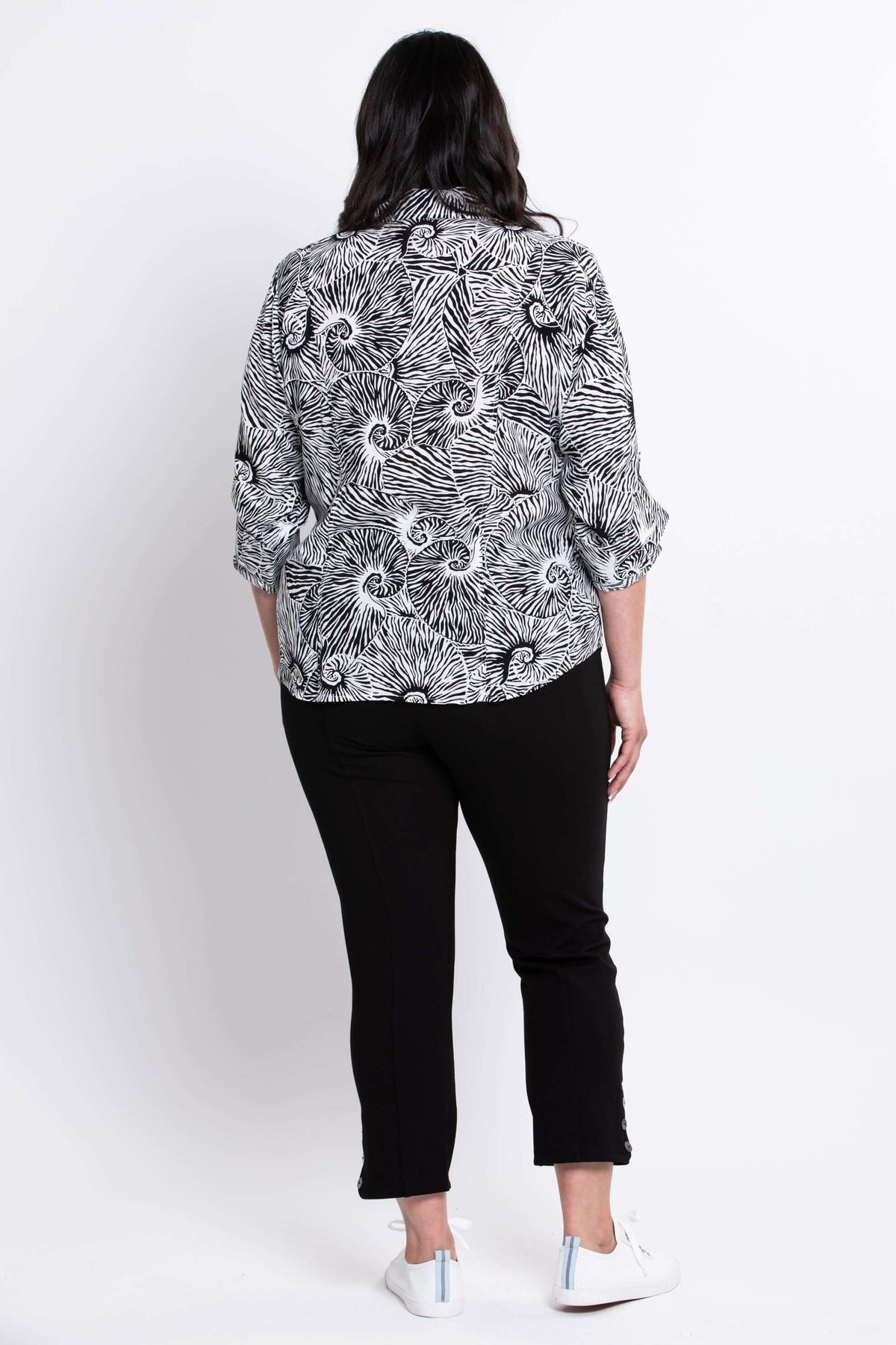 Back view of model in The Wendy black and white print blouse and black pants