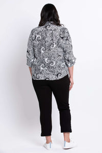 Back view of model in The Wendy black and white print blouse and black pants