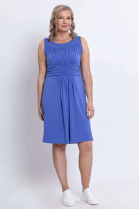 Three-quarter front view of woman wearing violet sleeveless ruched dress with waistband